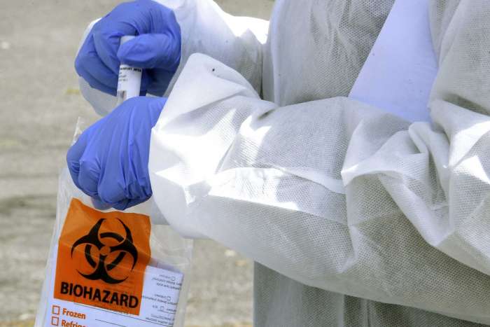 Ellis Hospital health care worker Sam Westbrook is seen putting a sample from a person into a biohazard bag at a coronavirus testing site at the Washington Irving Education Center on Wednesday, Tuesday, April 29, 2020 in Schenectady, N.Y. (Lori Van Buren/Times Union)